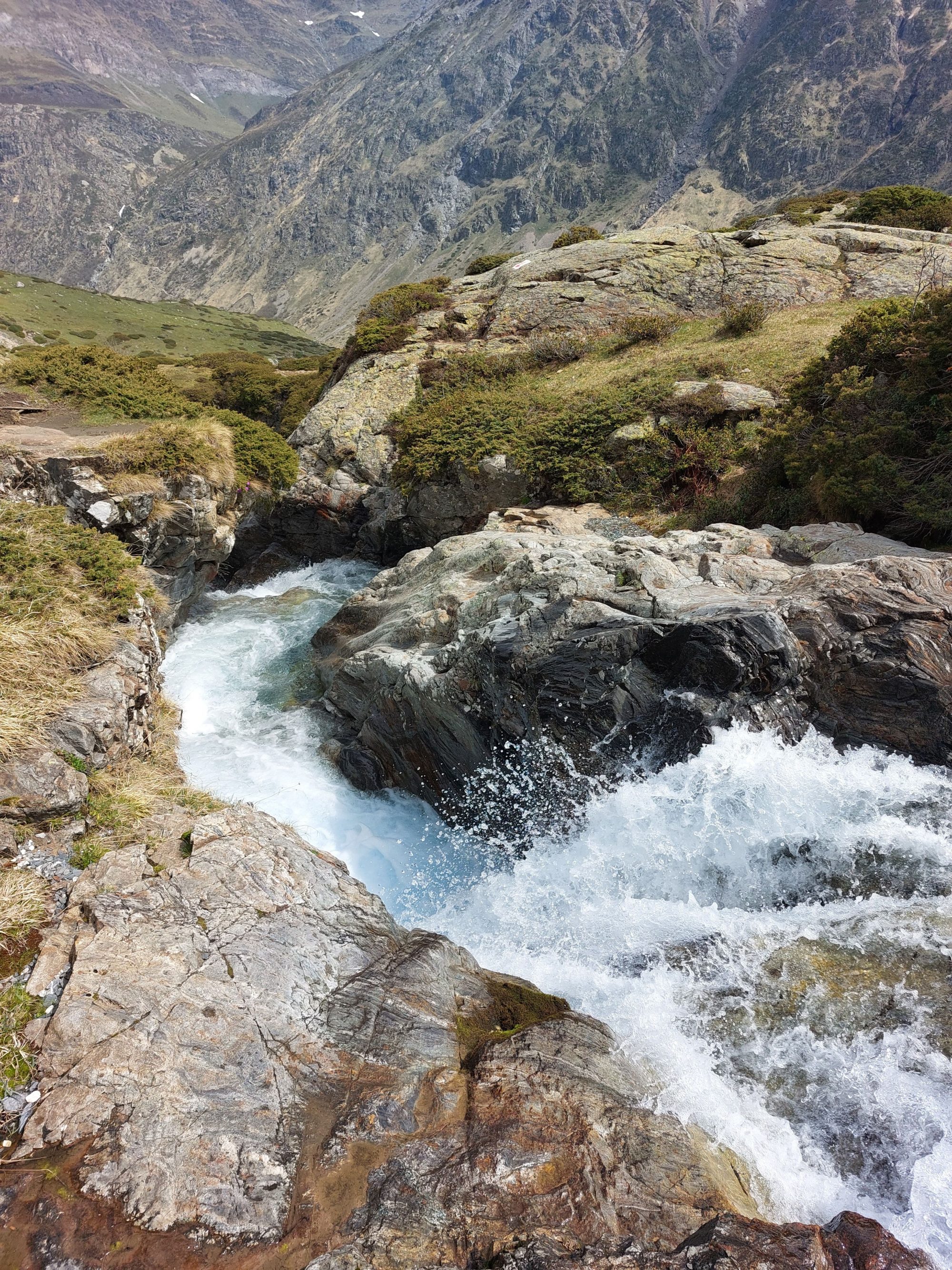A stunning view of a mountain stream cascading over rocks, showcasing the beauty of nature.